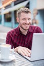 Portrait Of Young Man At Outdoor Cafe Working On Laptop Royalty Free Stock Photo