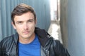 Portrait of young man outdoors with very handsome face in casual clothes against alley way urban background Royalty Free Stock Photo