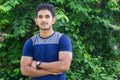 Portrait of young indian man in park on green background Royalty Free Stock Photo