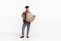 Portrait of young man playing accordion, posing isolated over white studio background. Countryside music Royalty Free Stock Photo