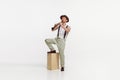 Portrait of young man playing clarinet isolated over white studio background. Countryside singer performing