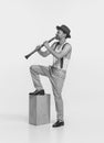 Portrait of young man playing clarinet isolated over white studio background. Expressive performance. Black and white