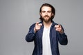 Portrait of young man pointing with his finger isolated on gray background Royalty Free Stock Photo