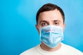 Portrait of young man in protective mask with pandemic text at blue background. and health care concept Royalty Free Stock Photo