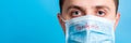 Portrait of young man in protective mask with pandemic text at blue background. and health care concept Royalty Free Stock Photo