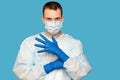 Portrait of young man in protective mask and protective suit puts on latex gloves against air pollution or transmissible Royalty Free Stock Photo