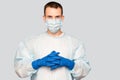 Portrait of young man in protective mask and protective suit puts on latex gloves against air pollution or transmissible Royalty Free Stock Photo