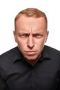 Portrait of young man questionably mistrustfully looking with lowered eyebrows on white background. Royalty Free Stock Photo