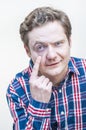 Man mistrustfully looking by opening one eye more with finger