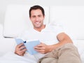 Portrait Of Young Man Reading Book On Bed Royalty Free Stock Photo