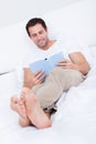 Portrait Of Young Man Reading Book On Bed Royalty Free Stock Photo