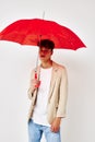 portrait of a young man red umbrella a man in a light jacket  background unaltered Royalty Free Stock Photo