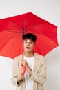 portrait of a young man red umbrella a man in a light jacket  background unaltered Royalty Free Stock Photo