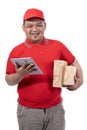 Portrait of young man with red uniform delivering boxes and holding digital tablet Royalty Free Stock Photo