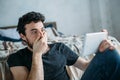 Portrait of a young man relaxing and watching a TV show on a tablet computer Royalty Free Stock Photo