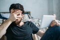 Portrait of a young man relaxing and watching a TV show on a tablet computer Royalty Free Stock Photo