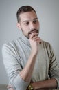 Portrait of a young man with a short beard biting his nails thinking seriously Royalty Free Stock Photo