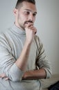 Portrait of a young man with a short beard biting his nails thinking seriously Royalty Free Stock Photo