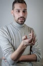 Portrait of a young man with a short beard speaks gesturing with his hands to explain something Royalty Free Stock Photo