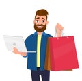 Portrait of young man showing shopping bags. Person holding a laptop computer in hand. Male character illustration. Royalty Free Stock Photo