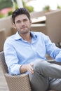 Portrait of young man sitting on chair at outdoors cafe Royalty Free Stock Photo