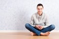 Portrait of young man sitting on the floor using a cellphone, isolated. ready for your design