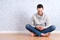 Portrait of young man sitting on the floor using a cellphone, isolated. ready for your design