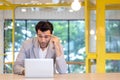 Portrait of young man sitting at his desk in the Modern office, Focused businessman working laptop thinking Royalty Free Stock Photo