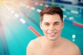 Portrait young man smiling on background of pool, concept of swimmer before training at school Royalty Free Stock Photo