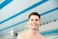 Portrait young man smiling on background of pool, concept of swimmer before training at school Royalty Free Stock Photo