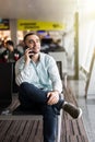 Portrait of a young man smiling talking mobile phone in airport Royalty Free Stock Photo