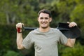 Portrait of young man standing with a gardening shovel