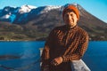 Portrait of young man standing on a wooden pier on background of mountains and lake. Place for text or advertising Royalty Free Stock Photo