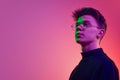 Portrait of young man, student in stylish clothes and glasses standing with proud face against gradient pink background Royalty Free Stock Photo