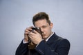 Portrait of a young man in a suit with an old camera, perhaps he is a novice journalist doing a report, a diplomat or secret