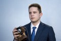 Portrait of a young man in a suit with an old camera, perhaps he is a novice journalist doing a report, a diplomat or secret