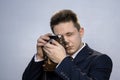 Portrait of a young man in a suit with an old camera, perhaps he is a novice journalist doing a report, a diplomat or secret agent