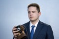 Portrait of a young man in a suit with an old camera, perhaps he is a novice journalist doing a report, a diplomat or secret agent