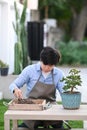Portrait of young man taking care of plants at back garden. Royalty Free Stock Photo