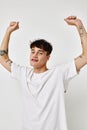 portrait of a young man tattoo on hands in white t-shirt light background unaltered Royalty Free Stock Photo