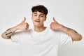 portrait of a young man tattoo on hands in white t-shirt light background unaltered Royalty Free Stock Photo