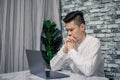 Portrait of young man thinking while serious working at home with laptop on desk