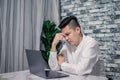 Portrait of young man thinking while serious working  at home with laptop on desk Royalty Free Stock Photo