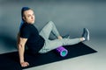 Portrait of a young man with an unusual hairstyle of mohawk from blue braids in sportswear doing leg exercise Royalty Free Stock Photo