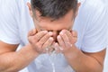 Portrait of young man washing face with a splash of water in the morning Royalty Free Stock Photo