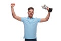 Portrait of young man wearing polo shirt celebrating with trophy Royalty Free Stock Photo