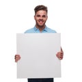 Portrait of young man wearing polo shirt holding blank sign Royalty Free Stock Photo