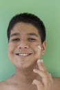 Portrait of young man with white cream. problematic skin and hyperpigmentation on his face smiling at camera Royalty Free Stock Photo