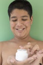 Portrait of young man with white cream. problematic skin and hyperpigmentation on his face smiling at camera Royalty Free Stock Photo