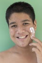 Portrait of young man with white cream. problematic skin and hyperpigmentation on his face smiling at camera